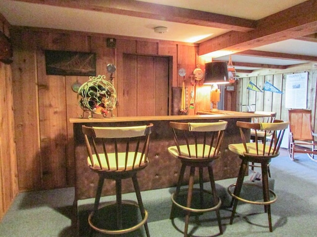 bar featuring a dry bar, carpet, wooden walls, and beamed ceiling