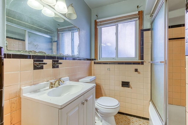 full bathroom featuring tile walls, combined bath / shower with glass door, tile patterned floors, vanity, and toilet