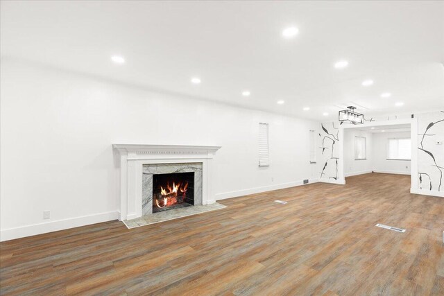 unfurnished living room featuring hardwood / wood-style floors and a high end fireplace