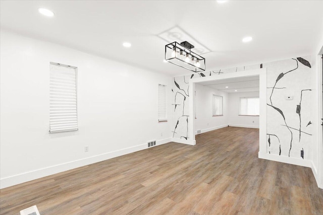 interior space with wood-type flooring and a notable chandelier