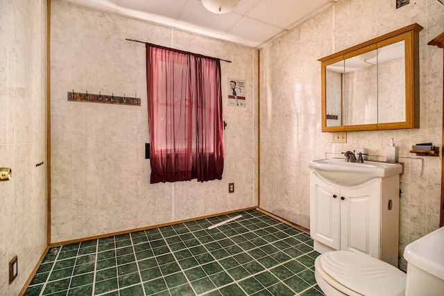 bathroom with vanity, tile walls, and toilet