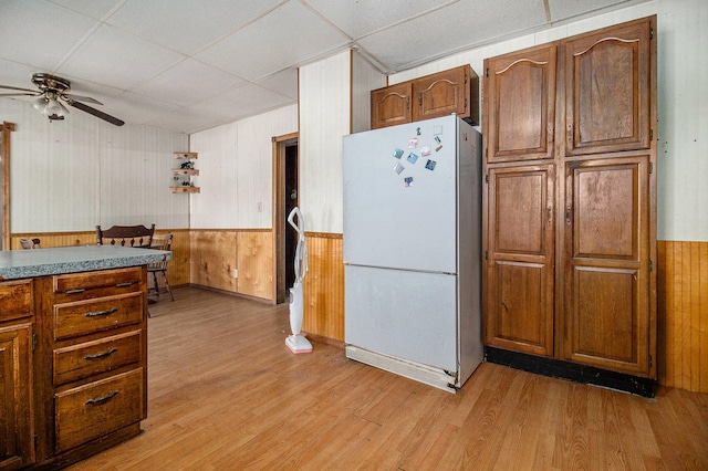 kitchen with light hardwood / wood-style flooring, white refrigerator, ceiling fan, and a paneled ceiling