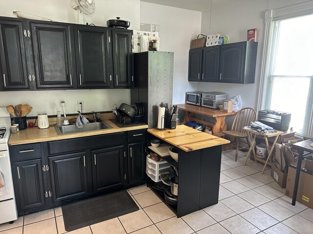 kitchen with sink, light tile patterned floors, and plenty of natural light