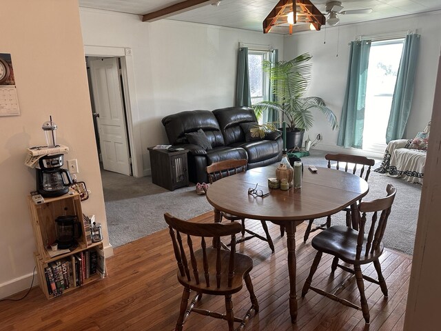 dining space featuring beam ceiling, ceiling fan, hardwood / wood-style flooring, and a healthy amount of sunlight