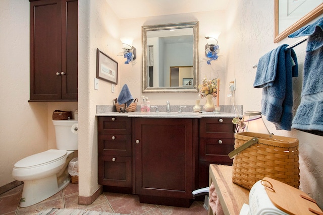 bathroom with tile patterned flooring, vanity, and toilet