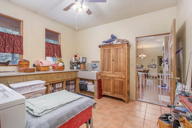 bedroom with light tile patterned floors and ceiling fan with notable chandelier