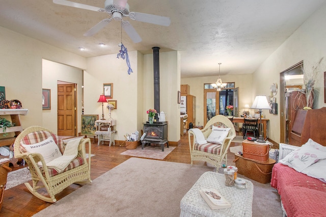 living room featuring hardwood / wood-style floors, ceiling fan, and a wood stove