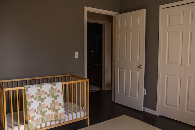 unfurnished bedroom featuring dark hardwood / wood-style floors and a crib