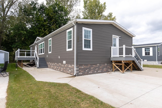 exterior space with a wooden deck, a patio, and a lawn