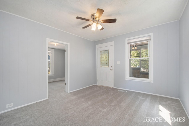 carpeted empty room featuring ceiling fan