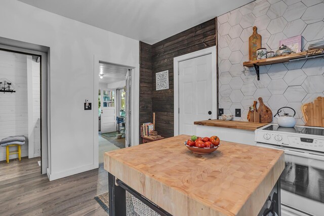 kitchen with white range oven, tasteful backsplash, wood walls, wooden counters, and hardwood / wood-style flooring