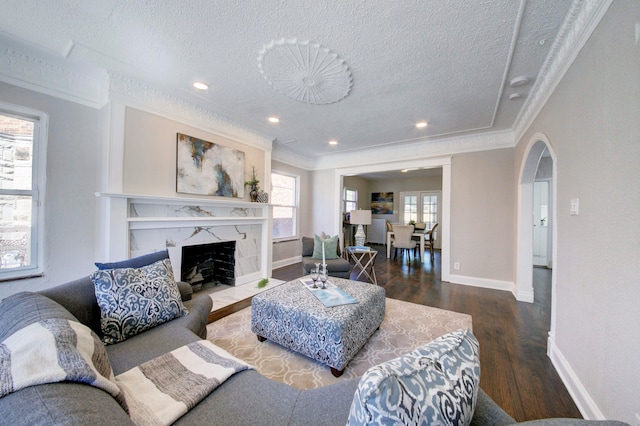 living room with a textured ceiling, dark wood-type flooring, and a wealth of natural light