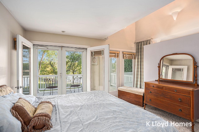 bedroom with access to outside, vaulted ceiling, and carpet flooring