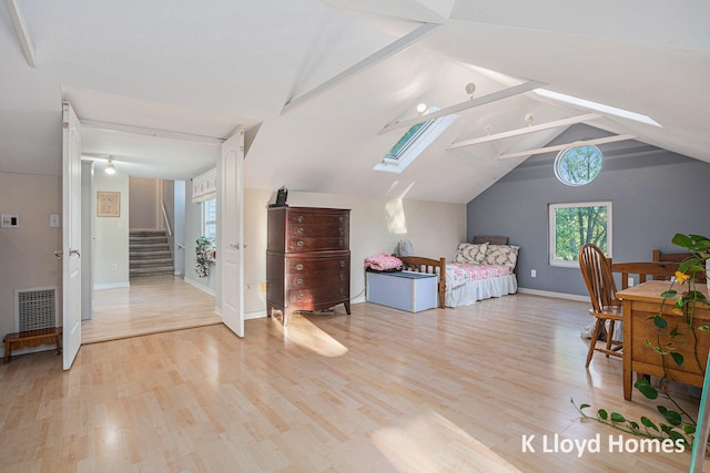 bedroom with light hardwood / wood-style floors and lofted ceiling with skylight