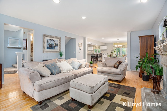 living room with light wood-type flooring and an inviting chandelier