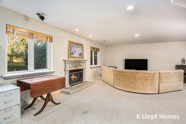 carpeted living room with a tiled fireplace