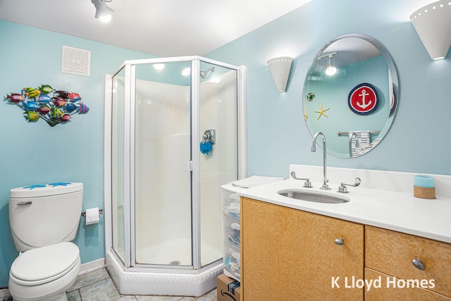 bathroom featuring walk in shower, vanity, toilet, and tile patterned floors