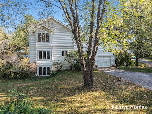 view of front of house featuring an outbuilding, a garage, and a front yard