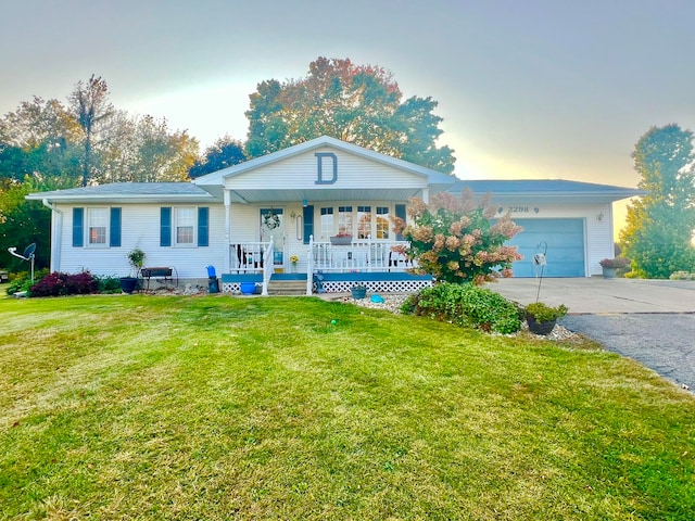 single story home featuring a garage, covered porch, and a yard