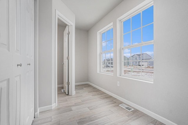 hallway featuring a healthy amount of sunlight and light wood-type flooring