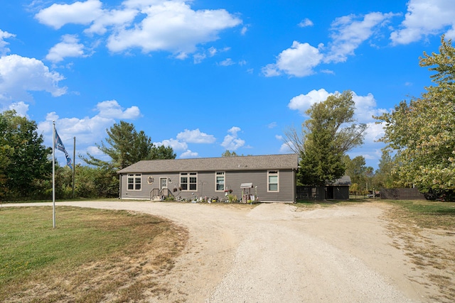 view of front facade with a storage shed and a front lawn