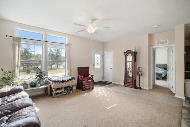 sitting room with ceiling fan and carpet flooring