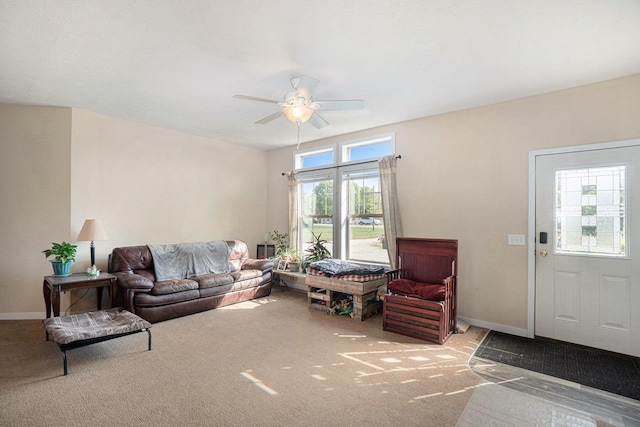 living room featuring a wealth of natural light, ceiling fan, and carpet floors