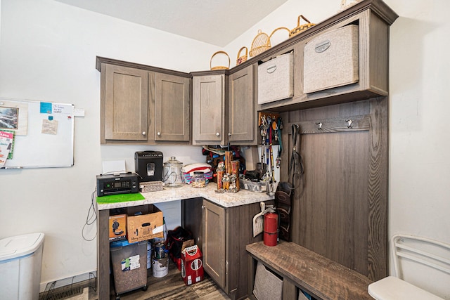 kitchen featuring dark brown cabinetry and dark wood-type flooring