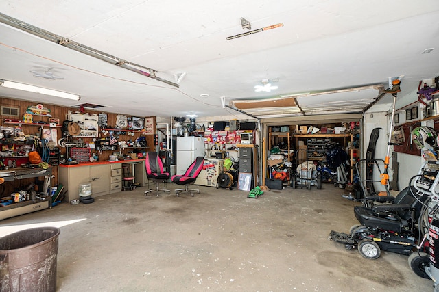 garage with a workshop area and white refrigerator