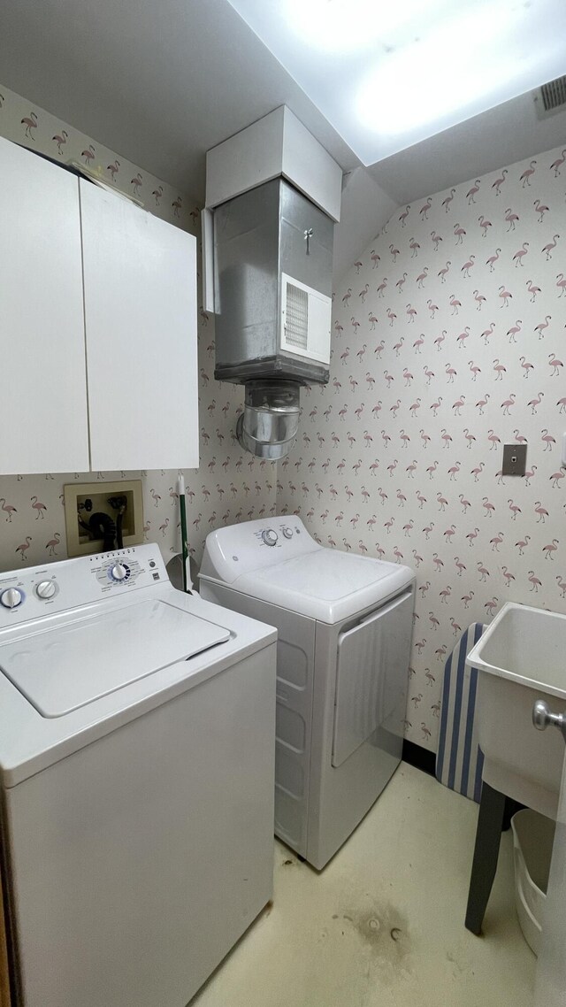 washroom with washing machine and clothes dryer and cabinets