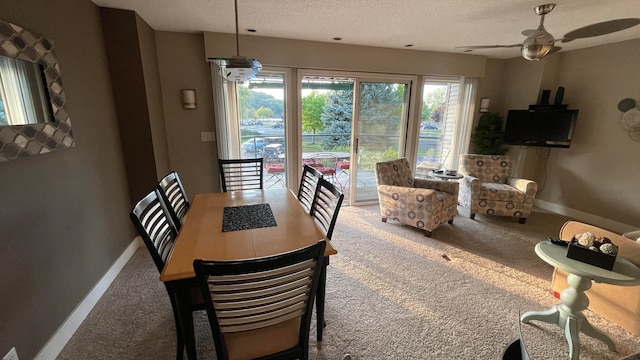 dining space featuring a textured ceiling, ceiling fan, and carpet flooring