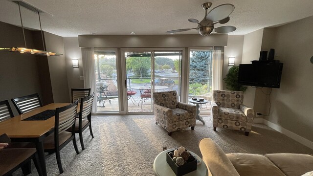 living room with ceiling fan, a textured ceiling, and carpet flooring