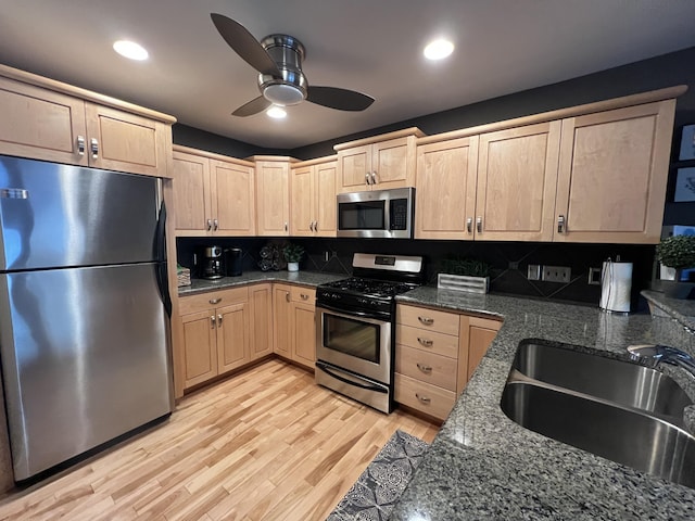 kitchen featuring backsplash, sink, light hardwood / wood-style flooring, appliances with stainless steel finishes, and light brown cabinetry