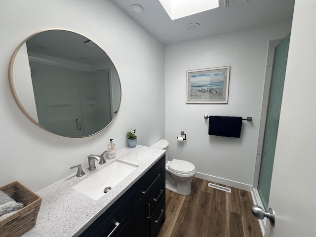 bathroom with toilet, a shower with shower door, wood-type flooring, and vanity