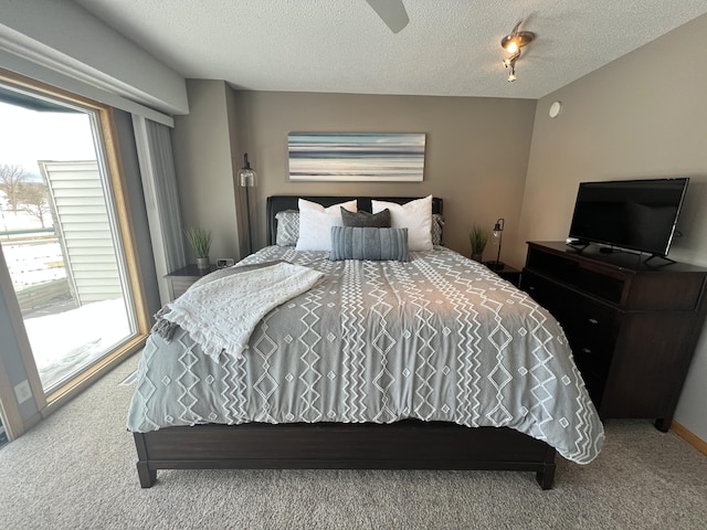 carpeted bedroom with ceiling fan, multiple windows, and a textured ceiling