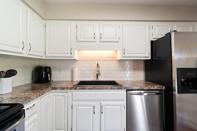 kitchen with white cabinets, appliances with stainless steel finishes, backsplash, and sink