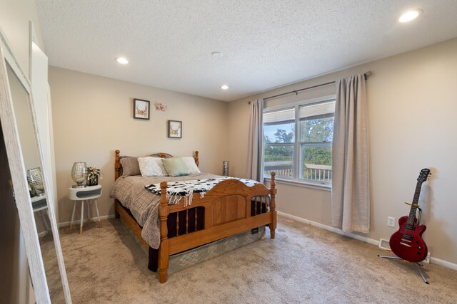 bedroom featuring a textured ceiling and light colored carpet