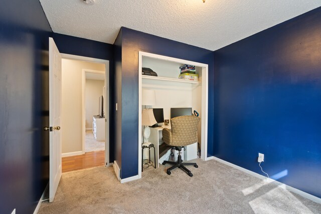 carpeted home office with a textured ceiling