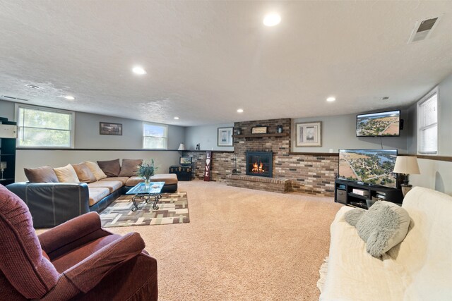 living room featuring a brick fireplace, a textured ceiling, and carpet flooring