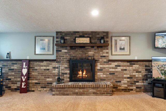 living room featuring a textured ceiling, carpet floors, and a brick fireplace