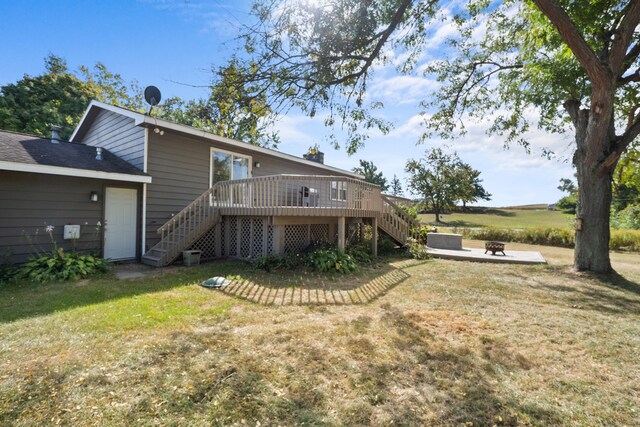 back of house with a deck and a lawn