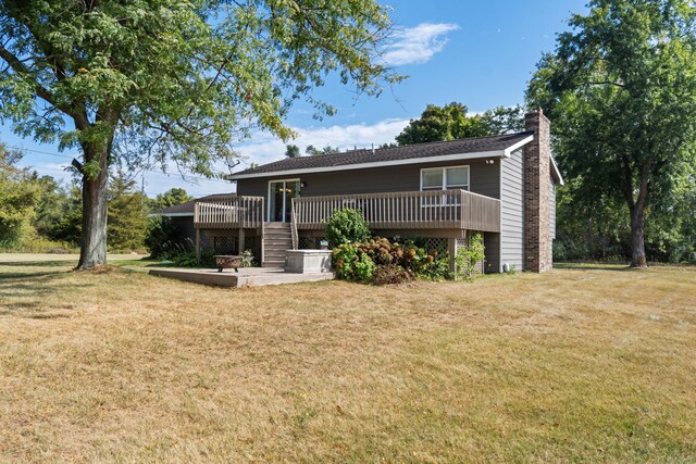 rear view of property with a wooden deck and a yard