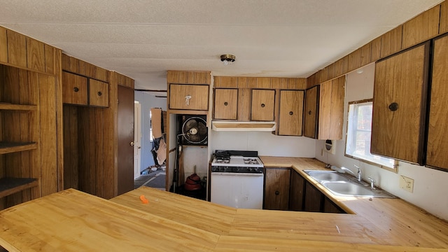 kitchen featuring butcher block counters, sink, kitchen peninsula, and white gas range oven