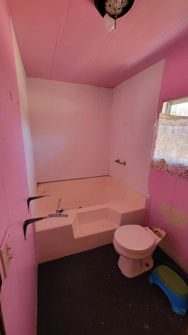 bathroom with toilet and a tub to relax in