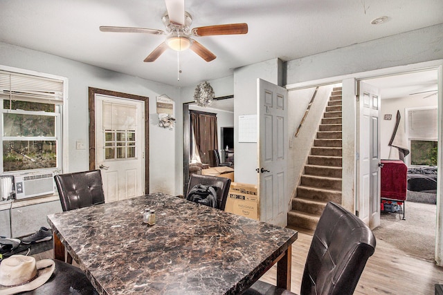 dining space featuring cooling unit, ceiling fan, and light hardwood / wood-style flooring