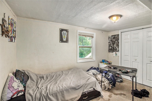 carpeted bedroom featuring a textured ceiling and a closet