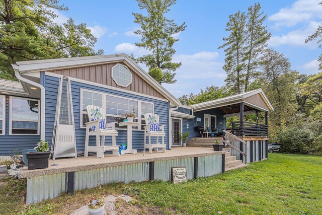 back of property with a lawn and a wooden deck