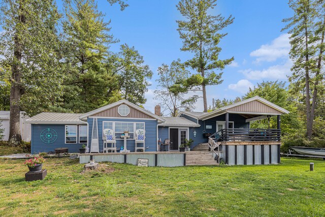 rear view of property with a wooden deck and a lawn