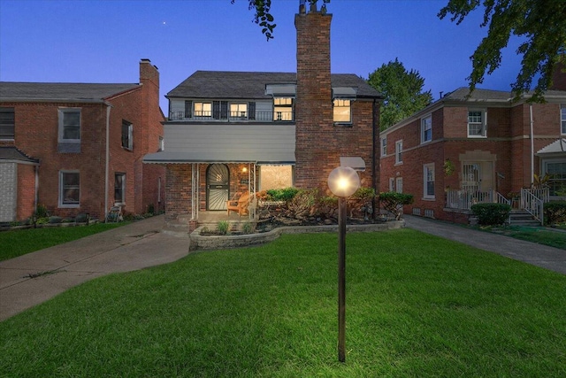 view of front of property featuring a balcony and a front yard