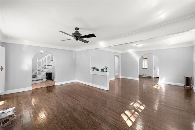 unfurnished living room with ceiling fan, a baseboard radiator, and dark wood-type flooring